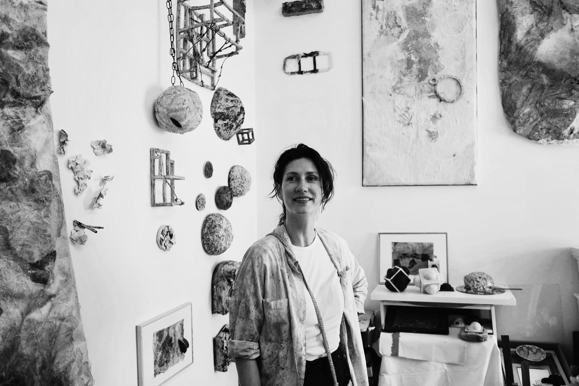 Evgeniya Korotchenko in her studio, with wall-mounted works behind her