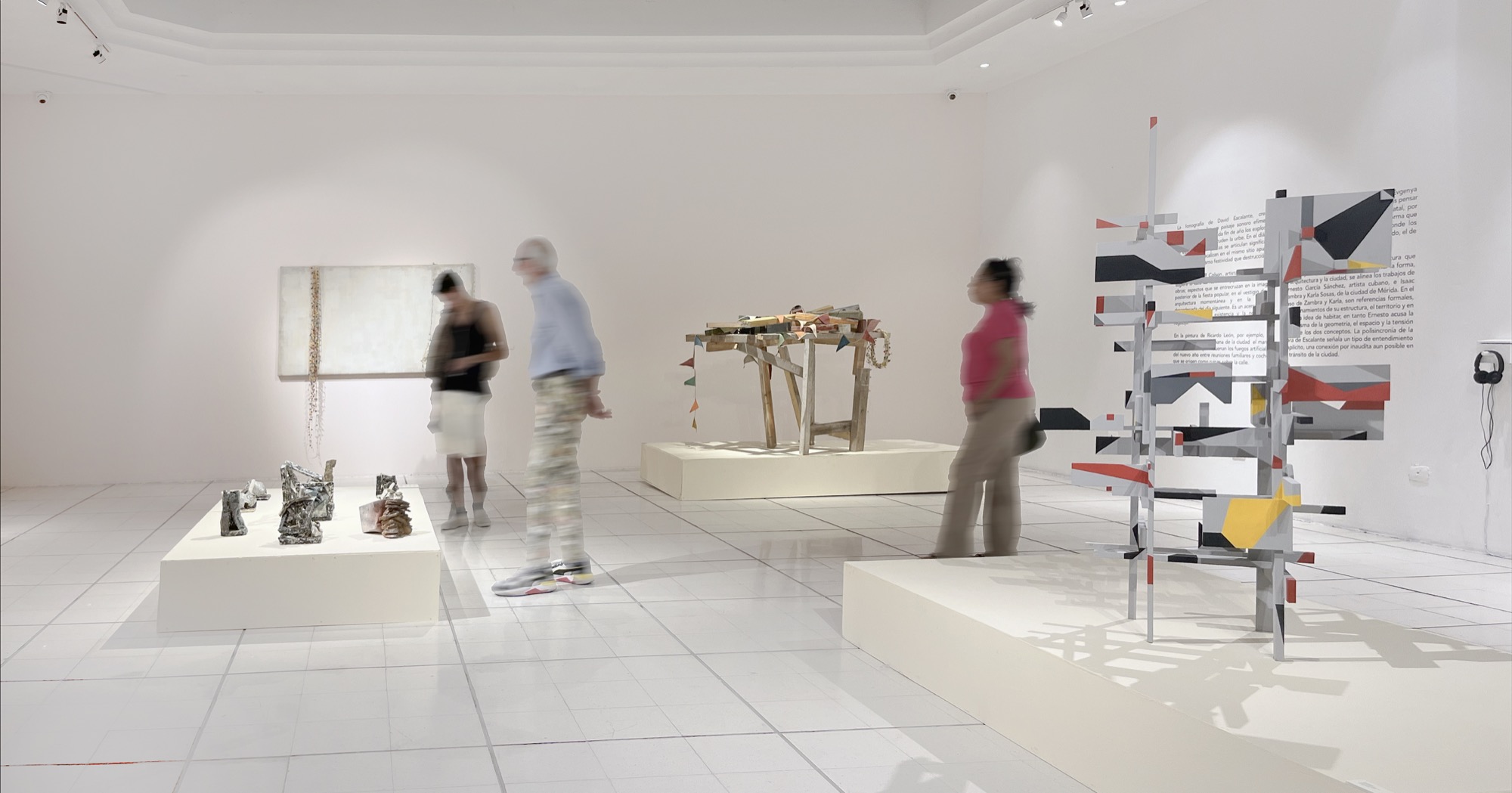 The gallery seen wide: a long white plinth carrying ceramic structures, with other artists' work along the walls