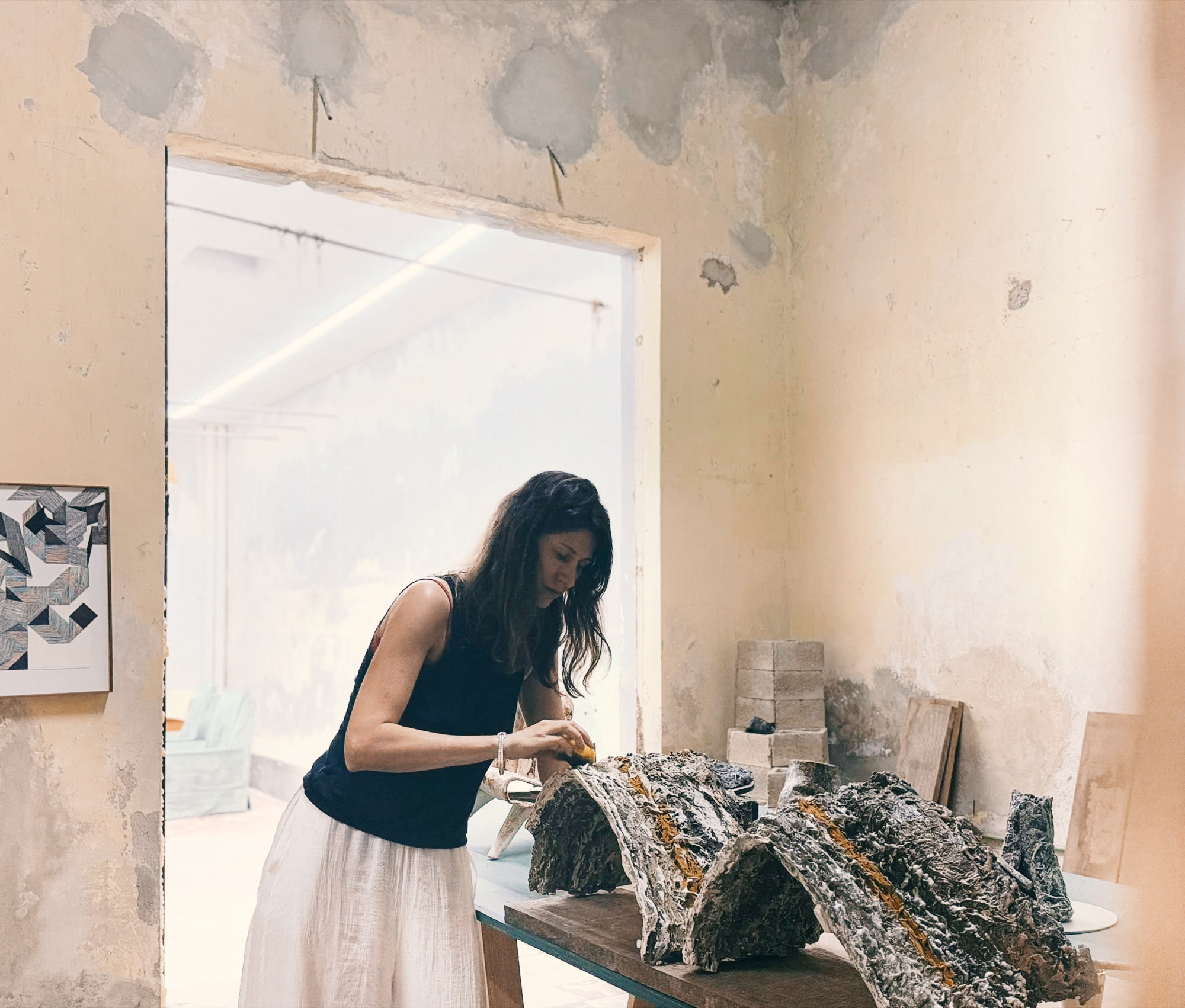 Working on four arch-shaped parts laid along a table in the Mérida studio, henequen fibre running along their ridges