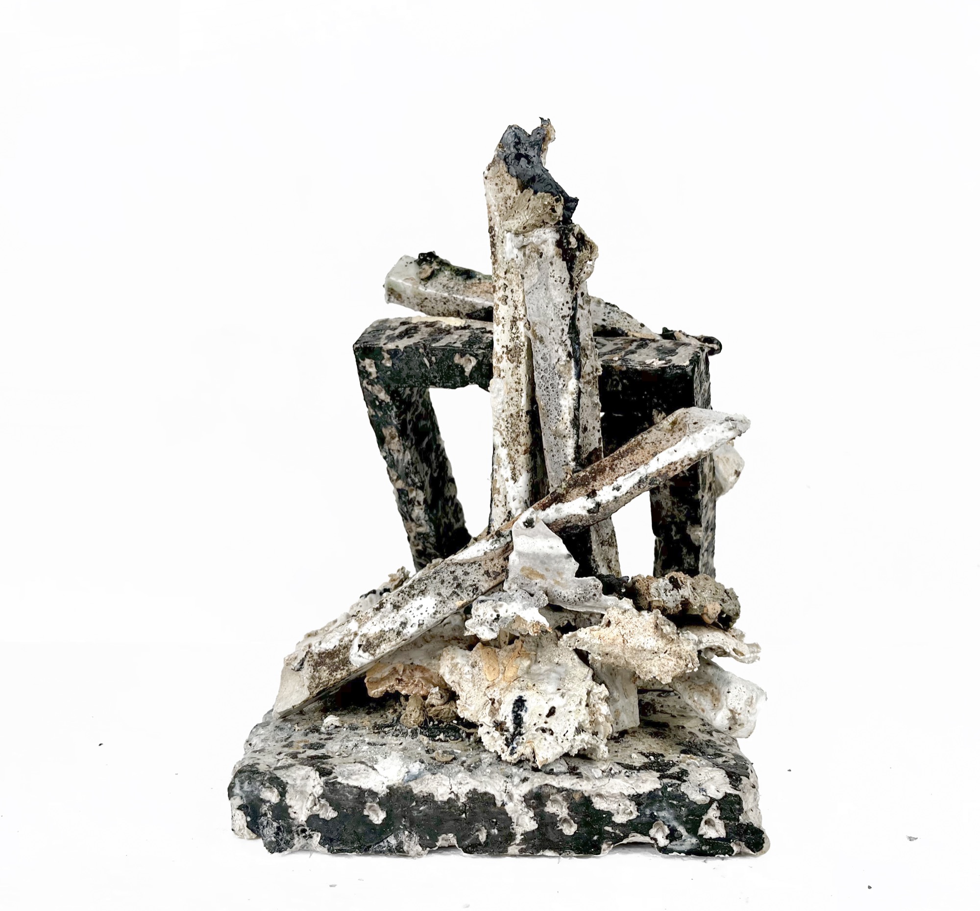 Collapsed Structures — ceramic beams leaning and fallen into a structure on an integral base, black and white, heavily encrusted