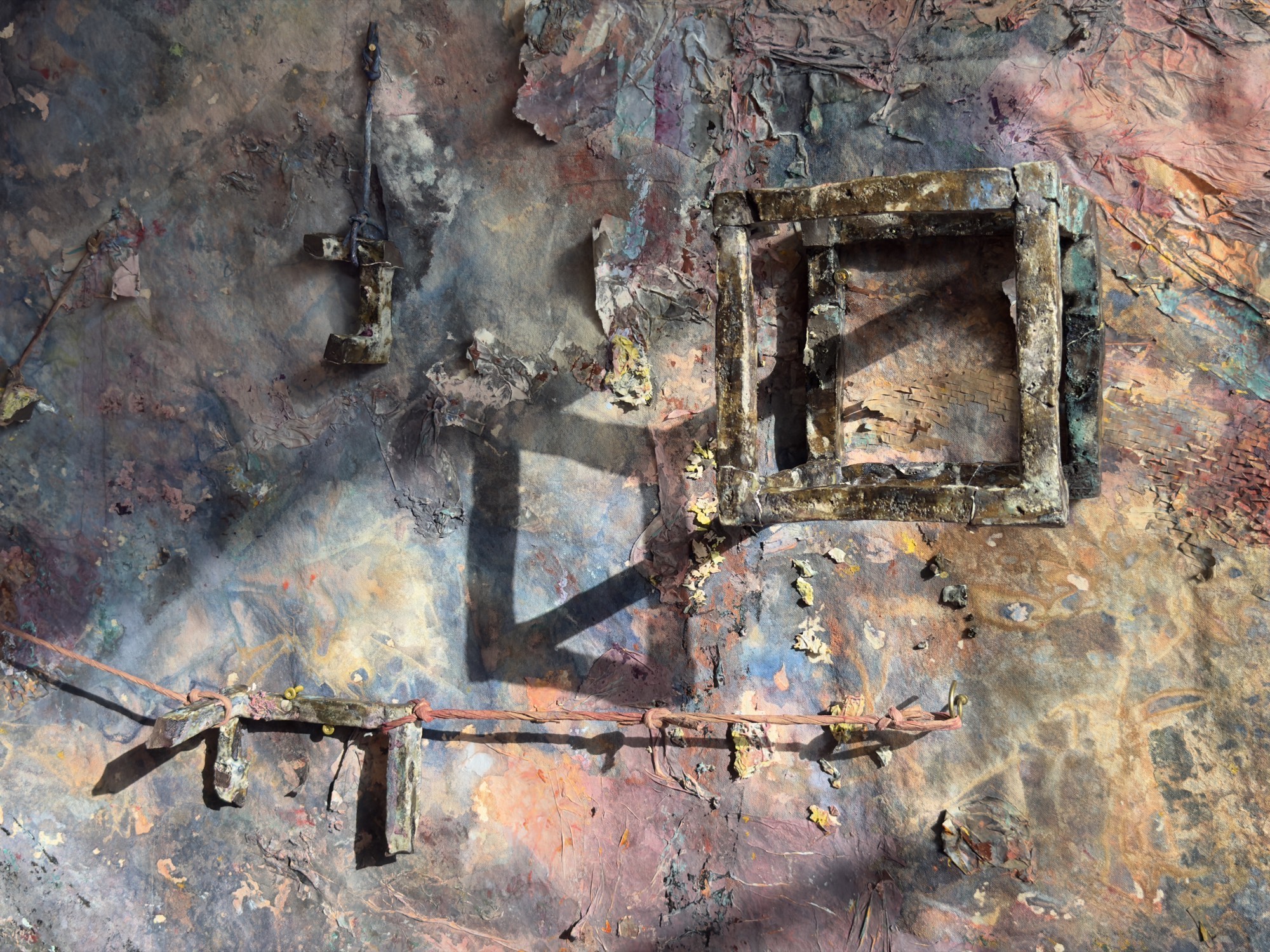 Detail: a ceramic window frame and a bound cord across the worked pink and blue ground