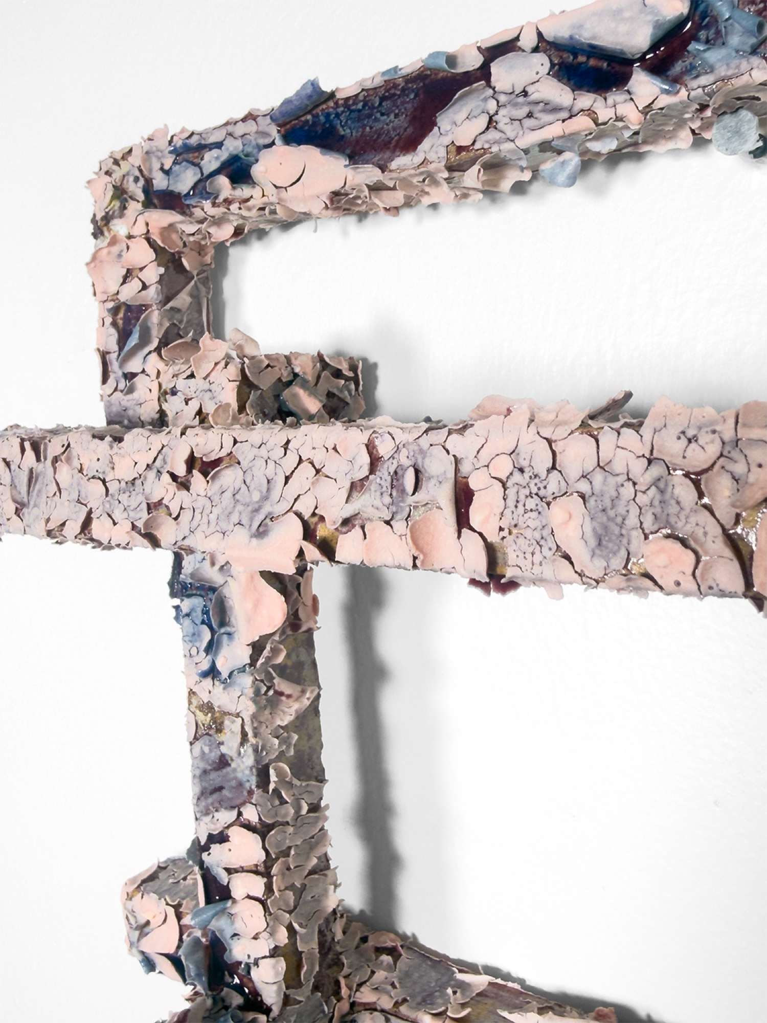 Detail: crust of pink and blue glaze plates over the frame