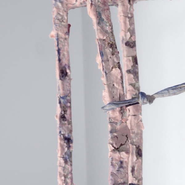 Detail of the grid: flaking porcelain skin and a knotted paper cord